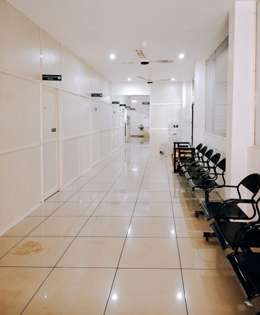 Clean modern hospital corridor with tiled floor and seating